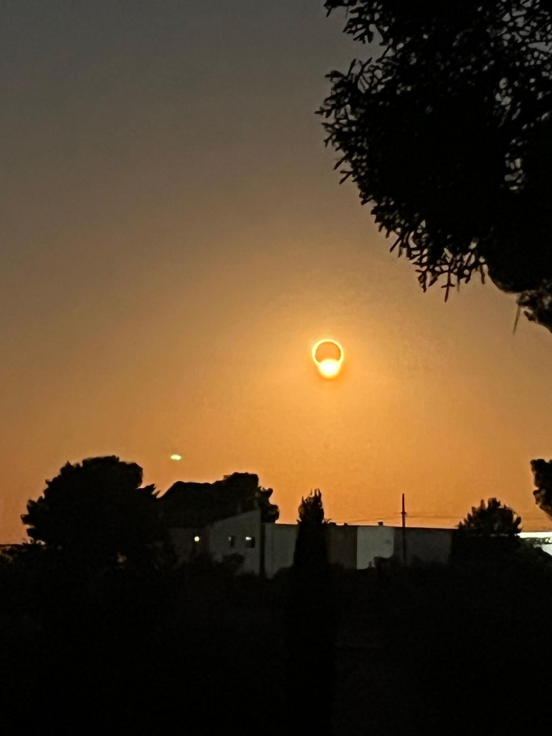 The eclipsed Sun as a bright ring low in a deep orange sky over Utiel-Requena on 12 August 2026